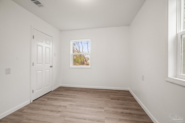 unfurnished room with visible vents, baseboards, and light wood-style floors