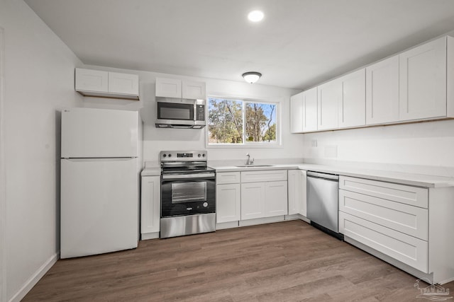 kitchen with a sink, stainless steel appliances, and white cabinetry