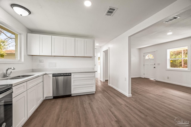 kitchen with dark wood finished floors, a sink, visible vents, and stainless steel dishwasher