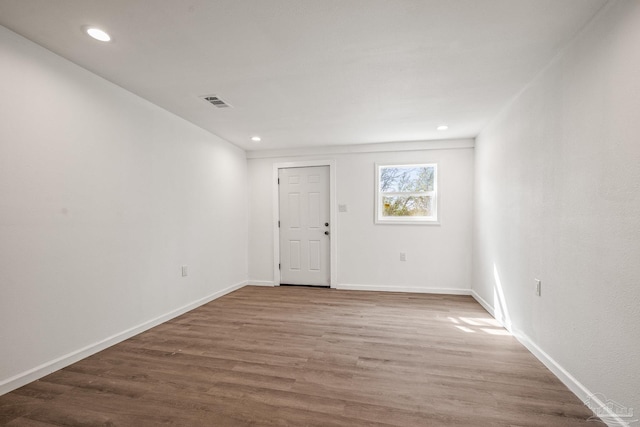 empty room featuring recessed lighting, baseboards, and wood finished floors