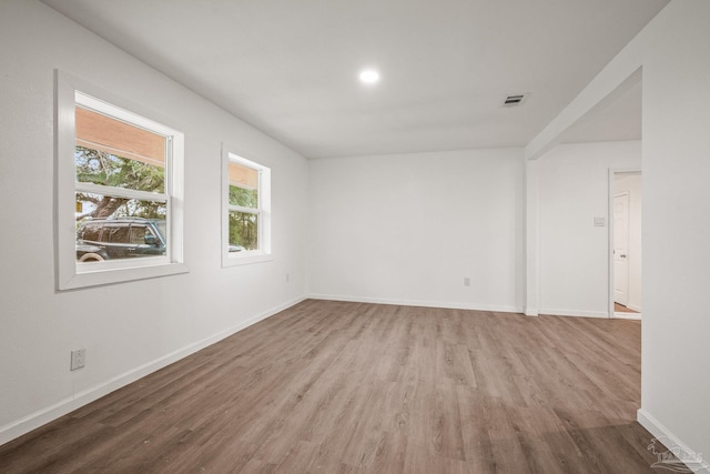 empty room featuring visible vents, recessed lighting, wood finished floors, and baseboards