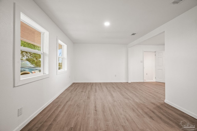 spare room with visible vents, baseboards, and wood finished floors