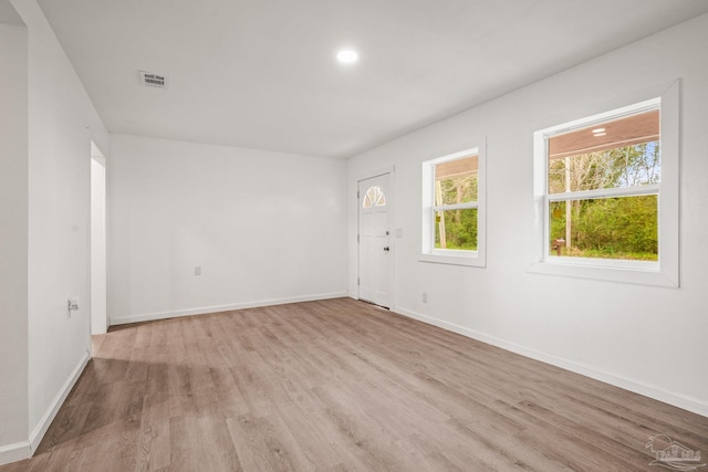 unfurnished room featuring recessed lighting, wood finished floors, visible vents, and baseboards