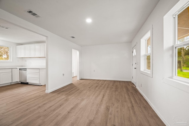 unfurnished living room featuring baseboards, visible vents, and light wood-type flooring