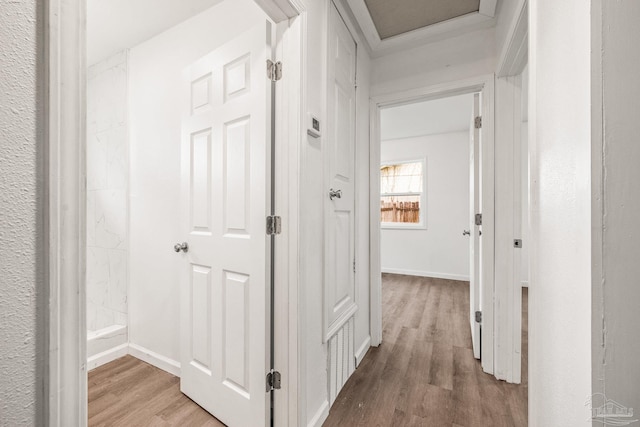 hall with baseboards and wood finished floors