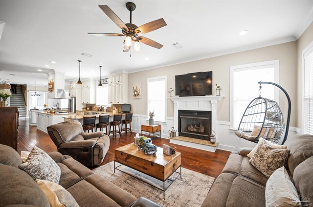 living room featuring ceiling fan, hardwood / wood-style floors, and ornamental molding