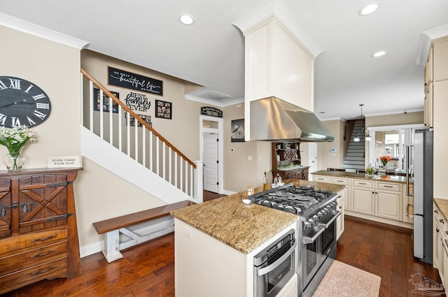 kitchen with dark hardwood / wood-style flooring, appliances with stainless steel finishes, pendant lighting, and a center island