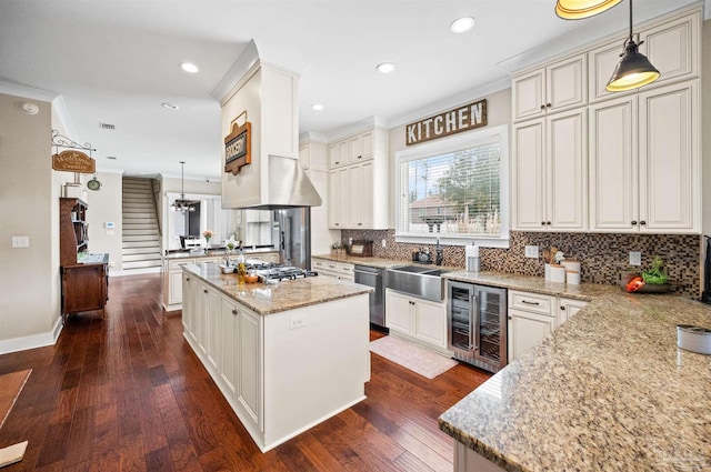 kitchen featuring pendant lighting, a kitchen island, and wine cooler