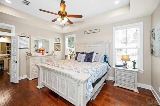 bedroom featuring ceiling fan, dark hardwood / wood-style flooring, and a raised ceiling