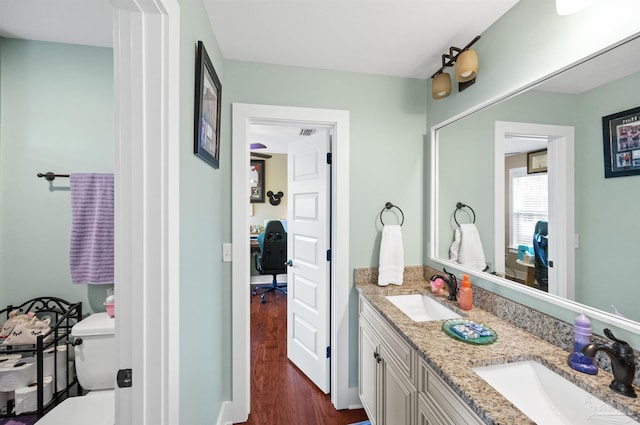 bathroom with hardwood / wood-style floors, vanity, and toilet