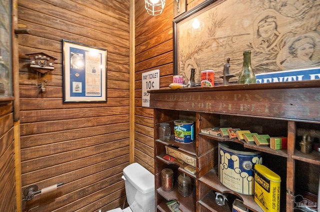 bathroom featuring toilet and wooden walls