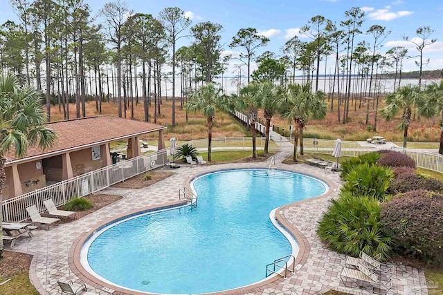 view of swimming pool with a patio and a water view