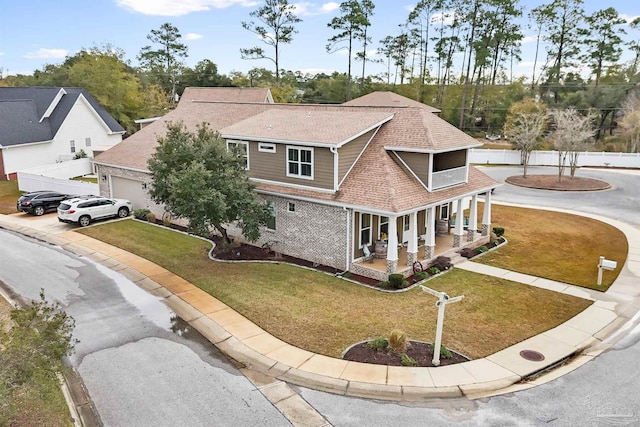 view of front of house with a front yard, a garage, and covered porch