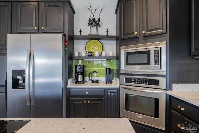 kitchen with stainless steel appliances, light stone countertops, open shelves, and tasteful backsplash