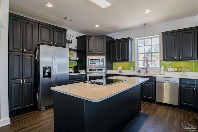 kitchen featuring a sink, stainless steel appliances, tasteful backsplash, visible vents, and dark wood-type flooring