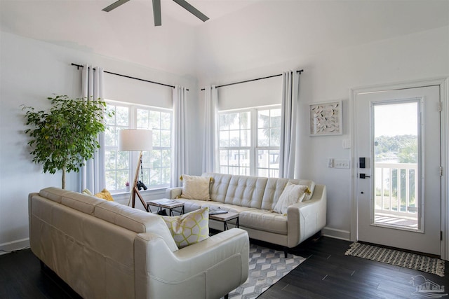 living area featuring baseboards, ceiling fan, and dark wood-style floors