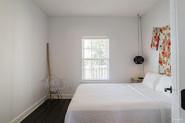 bedroom featuring baseboards and dark wood-type flooring
