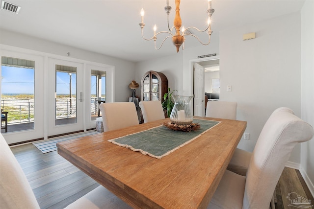 dining space featuring hardwood / wood-style flooring and a chandelier