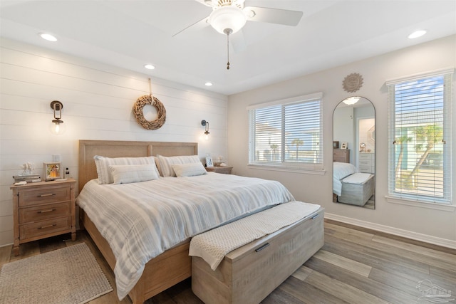 bedroom with multiple windows, light hardwood / wood-style floors, and ceiling fan