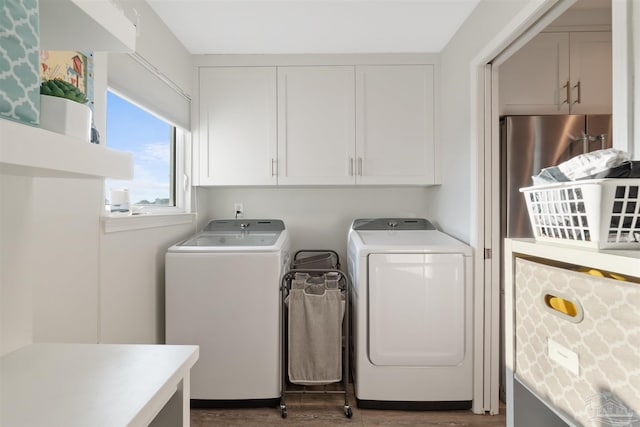 laundry area with cabinets, washing machine and clothes dryer, and dark hardwood / wood-style floors