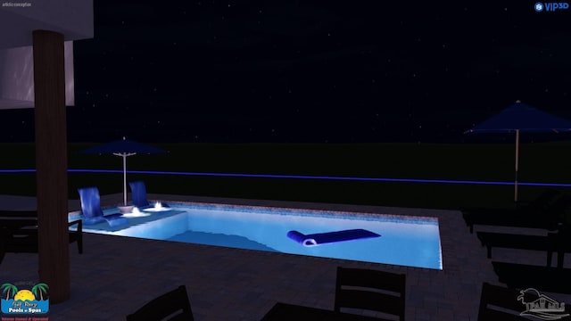 pool at night with a patio area