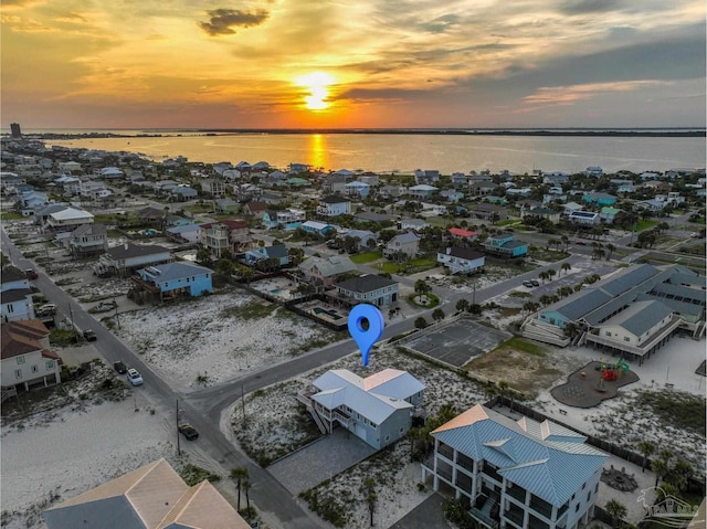 aerial view at dusk featuring a water view