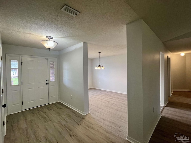 4888 La Casa Cir, Pace, FL 32571 - foyer with wood finished floors, baseboards, a chandelier, and a textured ceiling