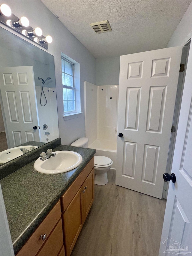 4888 La Casa Cir, Pace, FL 32571 - bathroom featuring wood finished floors,  shower combination, toilet, vanity, and a textured ceiling