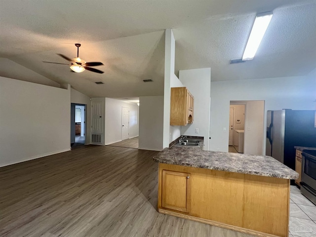 4888 La Casa Cir, Pace, FL 32571 - kitchen with a sink, open floor plan, a peninsula, a textured ceiling, and light wood-type flooring