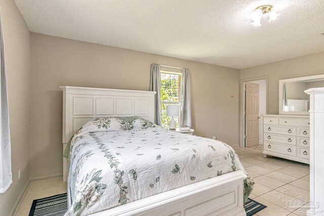 10449 Bernice Rd, Milton, FL 32583 - bedroom featuring light tile patterned flooring, a textured ceiling, and baseboards