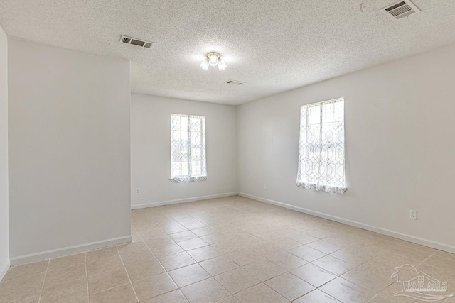 10449 Bernice Rd, Milton, FL 32583 - empty room with healthy amount of natural light, light tile patterned floors, baseboards, and a textured ceiling
