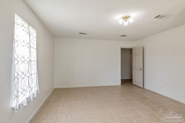 10449 Bernice Rd, Milton, FL 32583 - spare room with a textured ceiling, healthy amount of natural light, and baseboards
