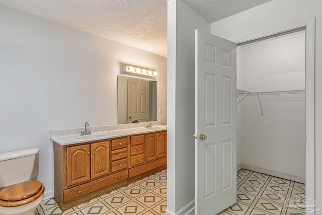 10449 Bernice Rd, Milton, FL 32583 - full bathroom with a textured ceiling, toilet, double vanity, and a walk in closet