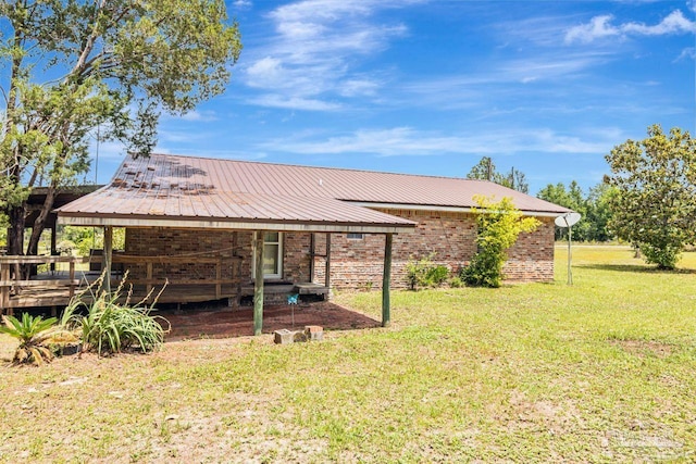 10449 Bernice Rd, Milton, FL 32583 - rear view of property featuring a yard, metal roof, a wooden deck, and brick siding