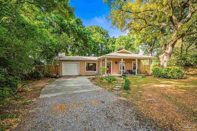 single story home featuring a garage, fence, a porch, and driveway