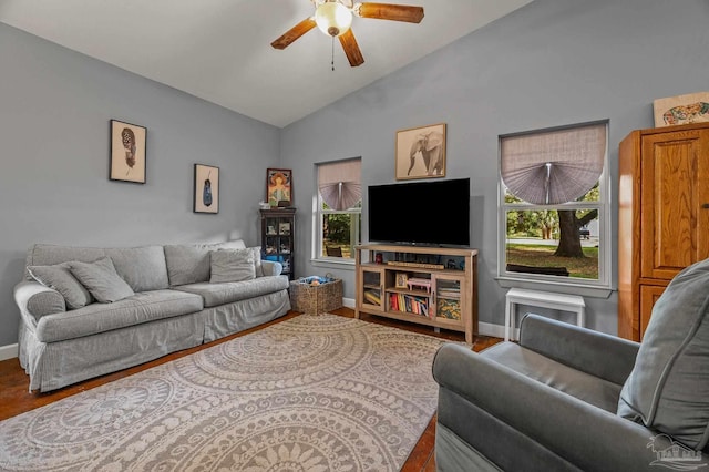 living room featuring a healthy amount of sunlight, ceiling fan, vaulted ceiling, wood finished floors, and baseboards