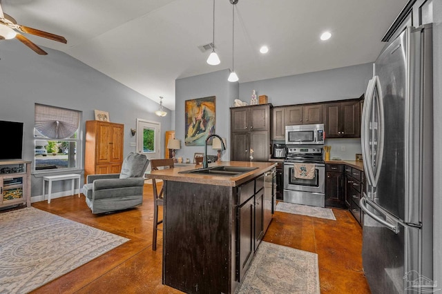 kitchen with open floor plan, ceiling fan, a kitchen breakfast bar, a sink, and stainless steel appliances