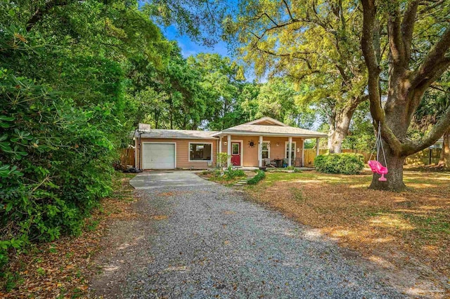view of front of home with a porch, an attached garage, and driveway