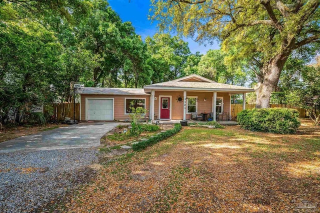 view of front of property with a porch, fence, driveway, and a garage