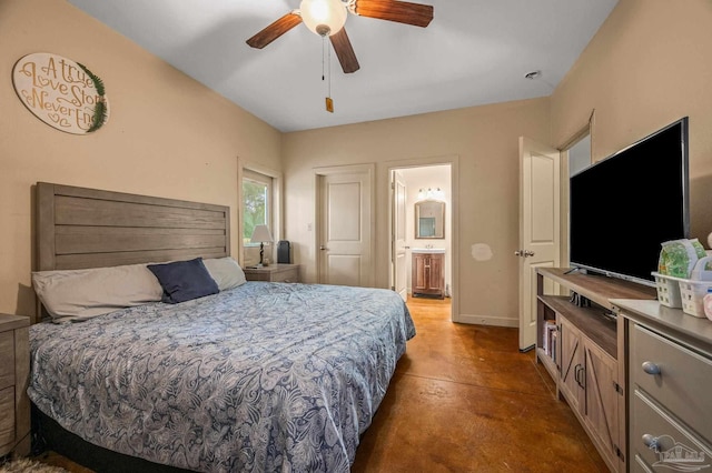 bedroom featuring concrete flooring, baseboards, a ceiling fan, and ensuite bath