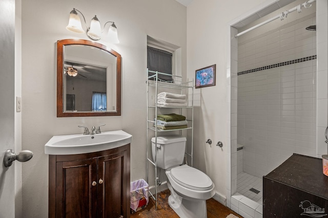 full bath with toilet, a tile shower, and vanity