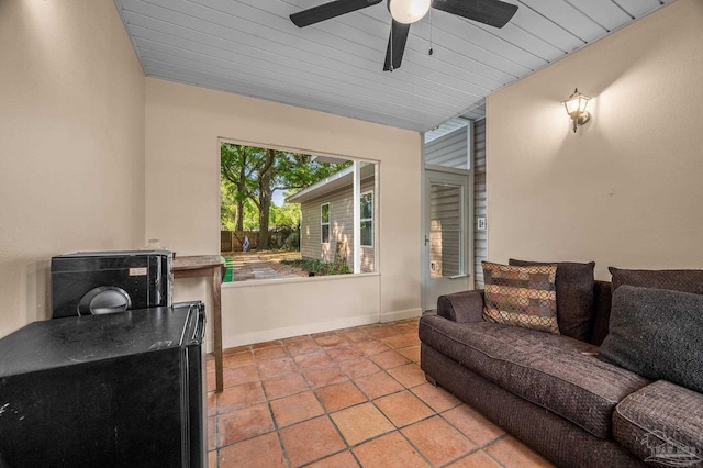 living area featuring baseboards and a ceiling fan