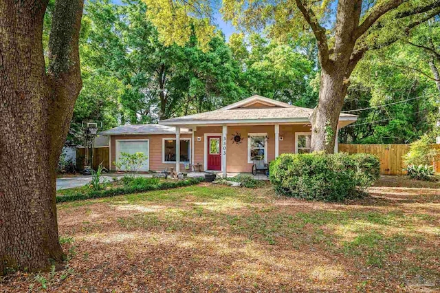 view of front of home featuring an attached garage, fence, and covered porch