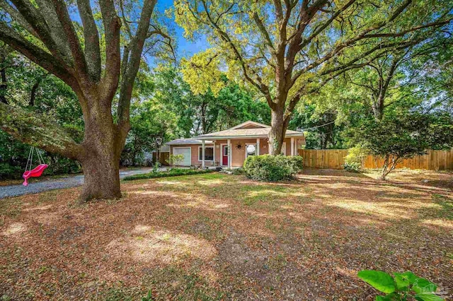 view of front of home with fence, covered porch, and a garage