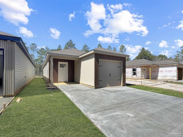 view of front of house featuring driveway, a shingled roof, and a front lawn