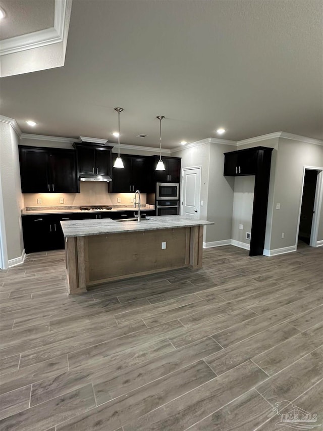 kitchen featuring a center island with sink, stainless steel appliances, and light hardwood / wood-style flooring