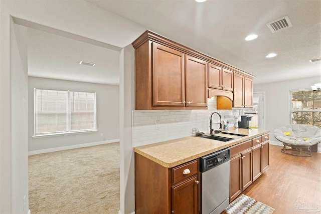 kitchen with decorative backsplash, stainless steel dishwasher, sink, and light hardwood / wood-style floors