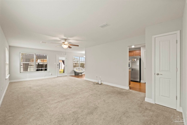 unfurnished living room with ceiling fan and light carpet