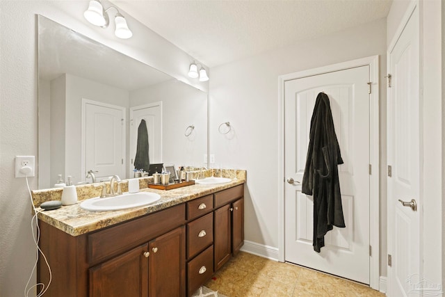 bathroom featuring tile patterned flooring, vanity, and a textured ceiling