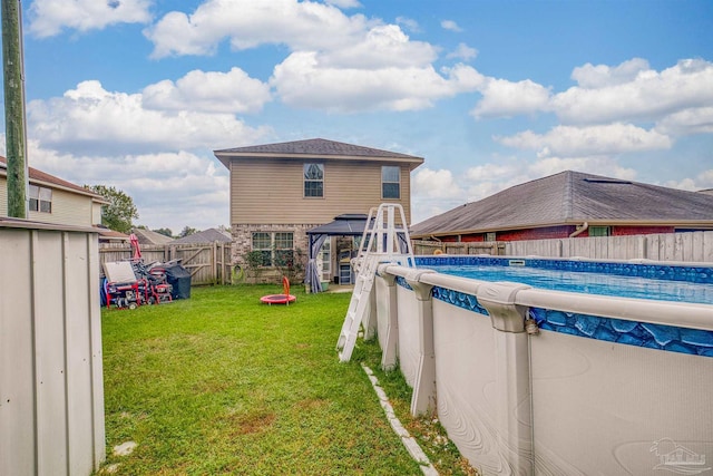 back of property with a fenced in pool and a yard